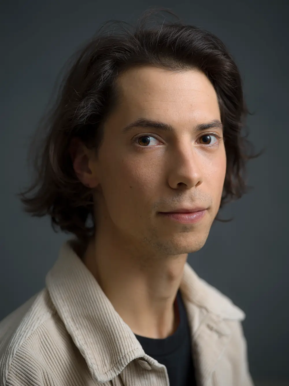 A portrait of the filmmaker Felix Rier in front of a dark background